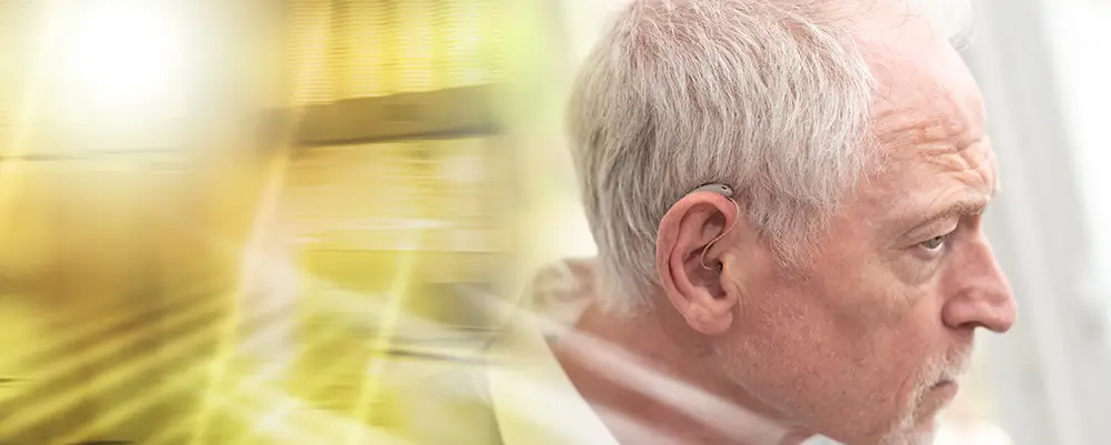 An elderly man wearing hearing aids