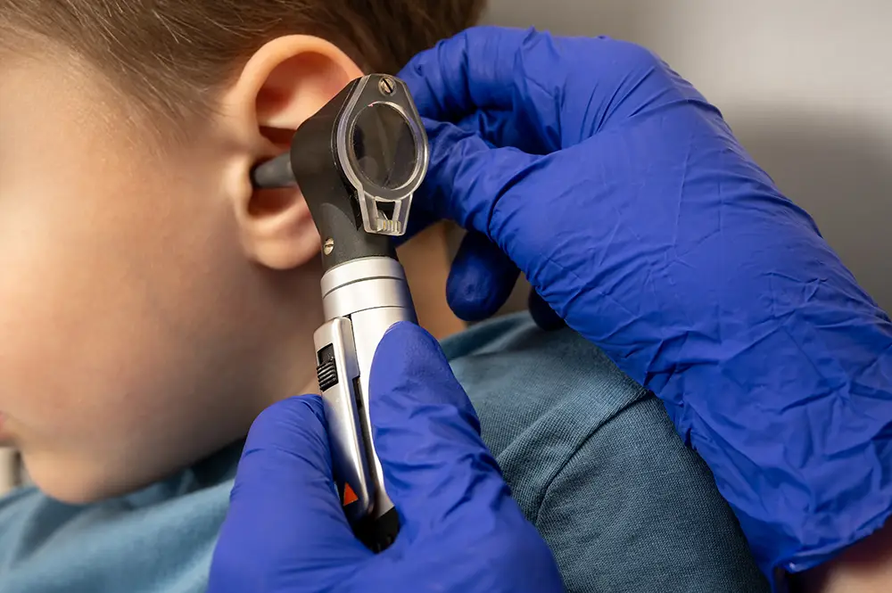 A child having their ears examined for an earwax blockage.