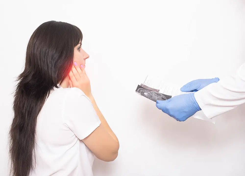 A woman touching her jaw