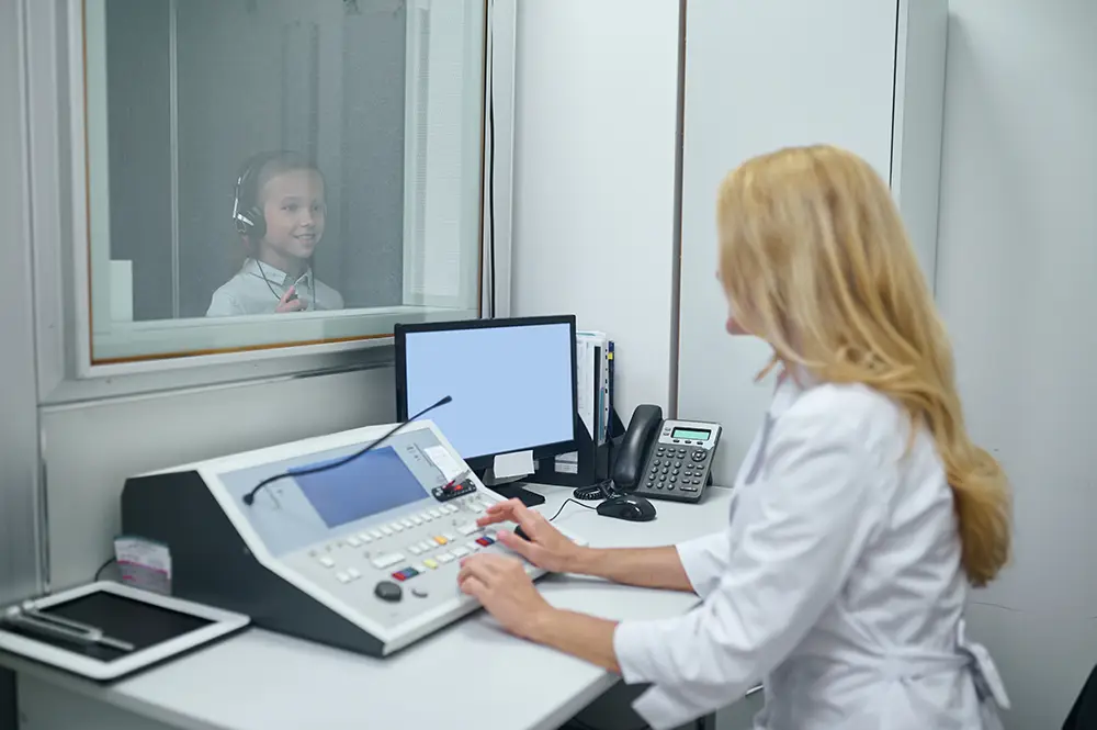 A boy undergoing a hearing test in a doctor's office