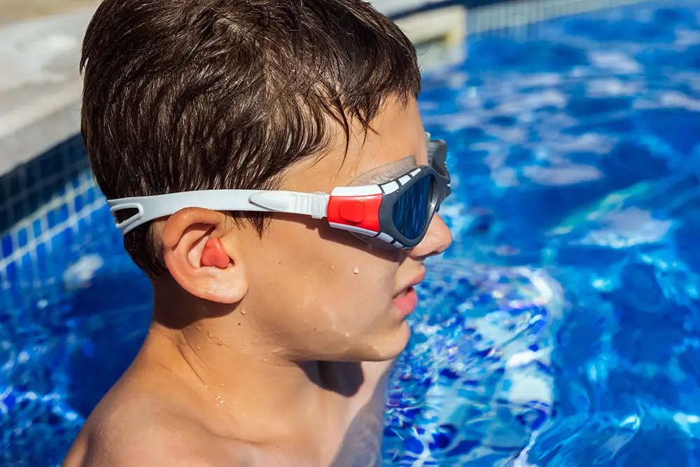 A boy wearing goggles in a swimming pool