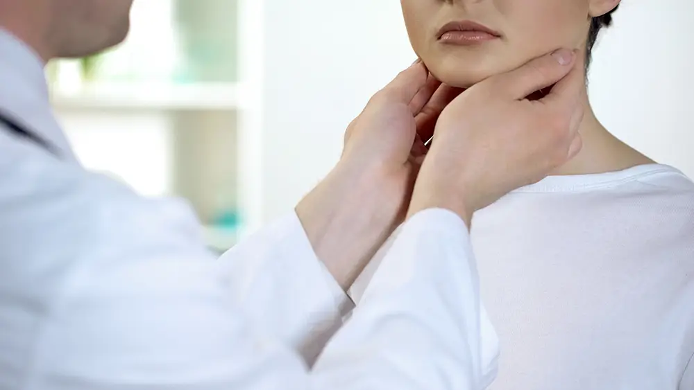 A female patient getting her neck checked by a doctor
