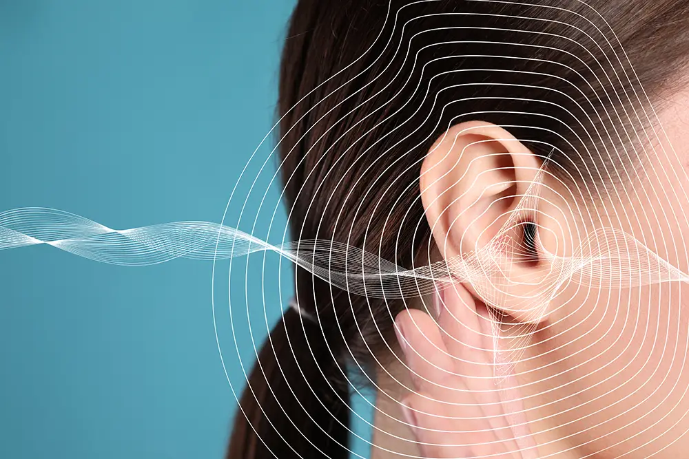 Photo of an ear overlaid with illustrations of sound waves